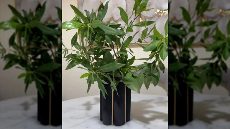 DIY paper towel roll vase with green houseplant on white marble tabletop