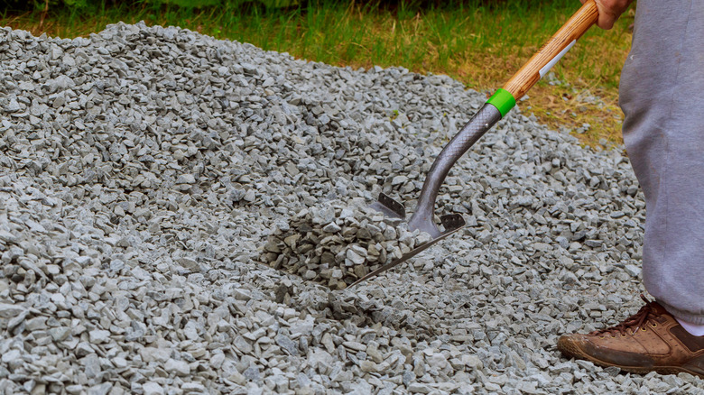 Person spreading gravel with a shovel