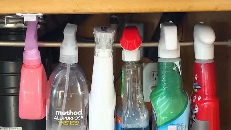 Bottles of cleaning products hung on curtain rod