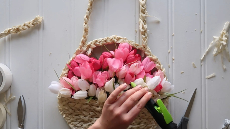 Creator putting the finishing touches on a pizza pan hanger that looks like a flower basket
