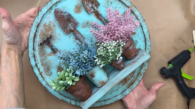 Creator holding a garden-themed pizza pan display