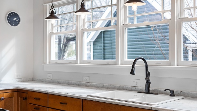 A bright kitchen window and wooden cabinetry