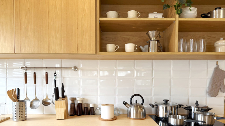 A white kitchen with wooden cabinets and open shelving