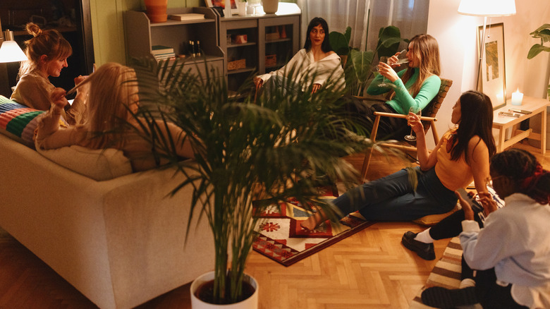 A group of women sit in a living room while visiting