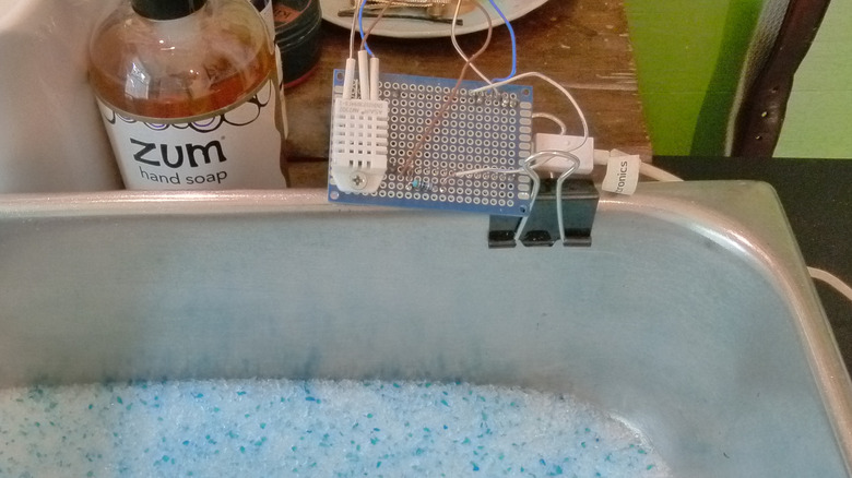 Silica gel cat litter in an open pan with a humidity sensor