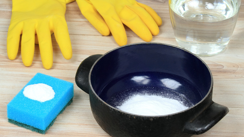 A person mixing baking soda and water in a bowl for cleaning