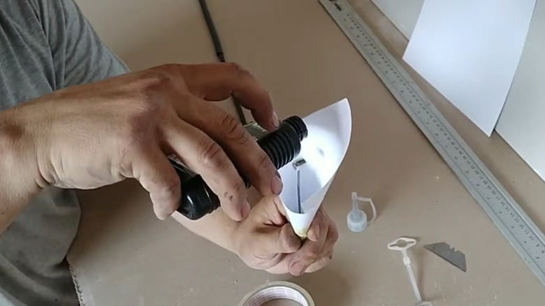 A person pouring graphite powder over a cable