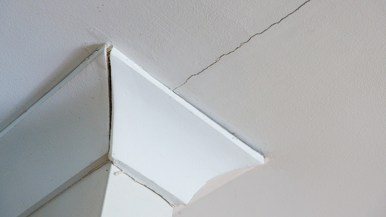 A hairline crack at the top of a pillar on the ceiling.