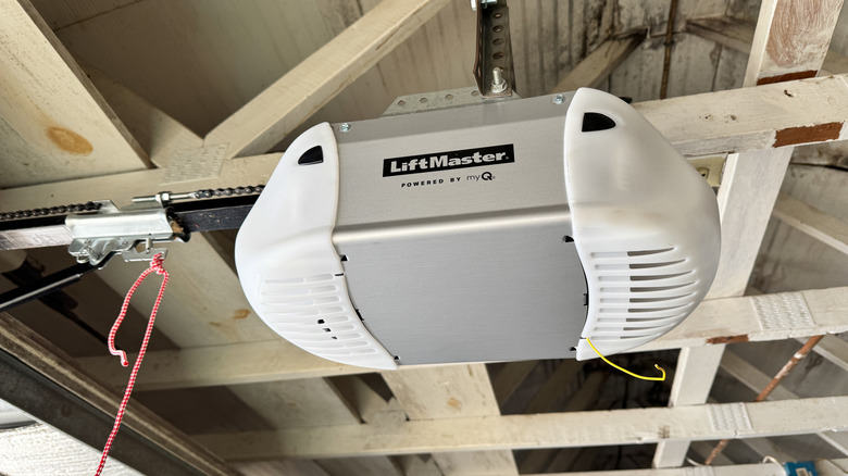A LiftMaster brand garage door opener motor unit mounted to the roof of a garage.