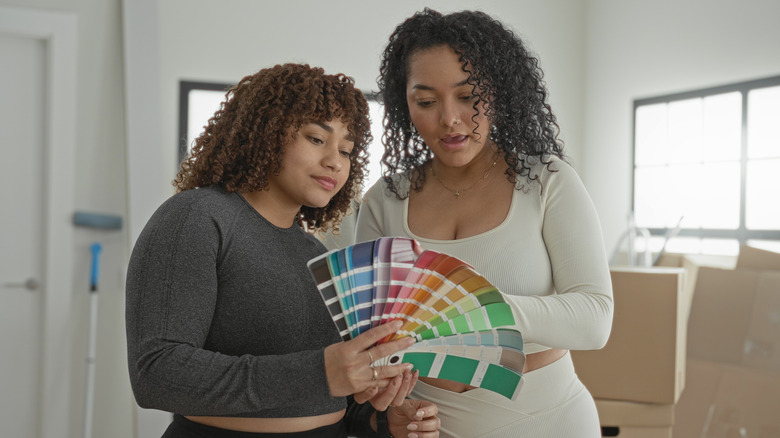 Two women looking at paint color options