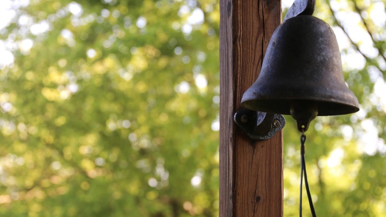 Dinner bell hanging from porch rafter