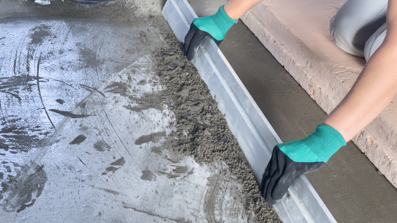 a worker levels a concrete patio.