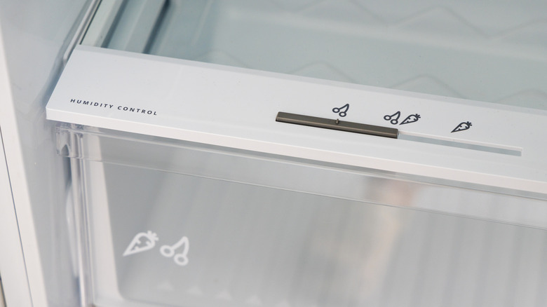A crisper drawer with the words "humidity control" next to a slider with illustrations of fruits and vegetables.