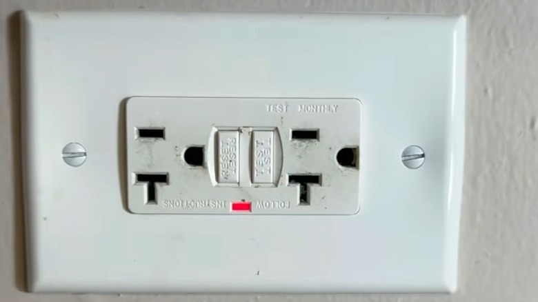 A wall socket with the red LED light on