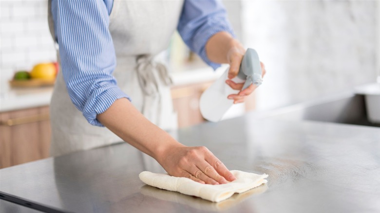 Woman spraying counter with cleaning vinegar