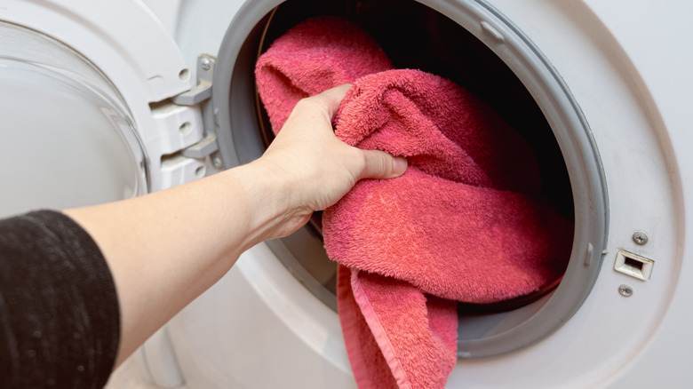 hand putting towel in dryer
