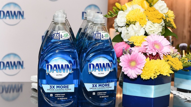 Bottles of Dawn dish soap next to a flower bouquet