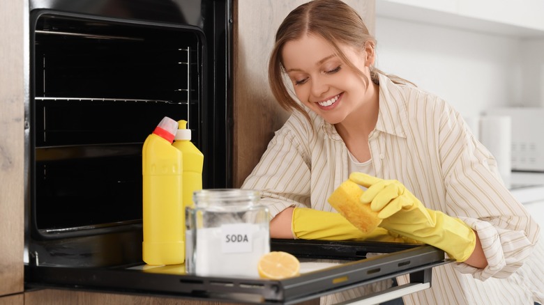 Happy woman cleaning ven glass door with baking soda
