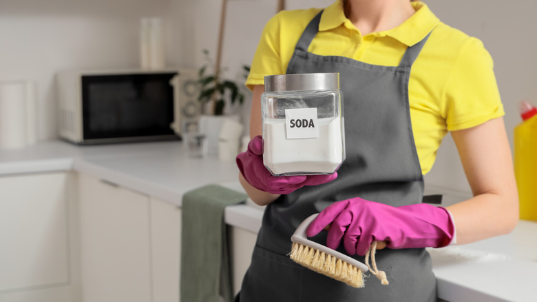 A woman holds a container of baking soda