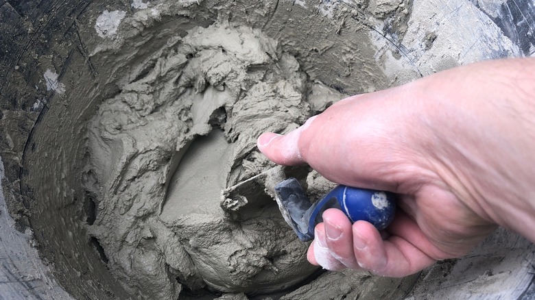 Closeup of person mixing concrete with a trowel