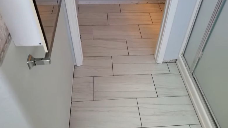 Large tiles on a hallway floor, arranged in a 1/3 offset
