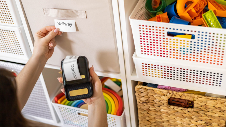 Person labeling baskets of items for organization