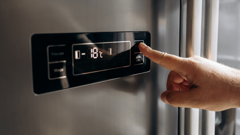 Finger pushing button on refrigerator