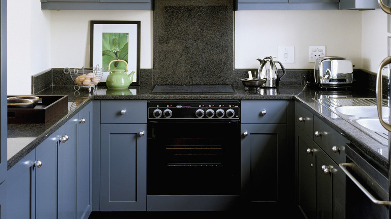 A kitchen with blue cabinets showcasing an oven prominently