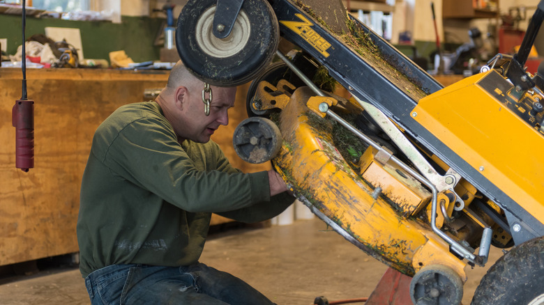 Man working on a riding lawn mower