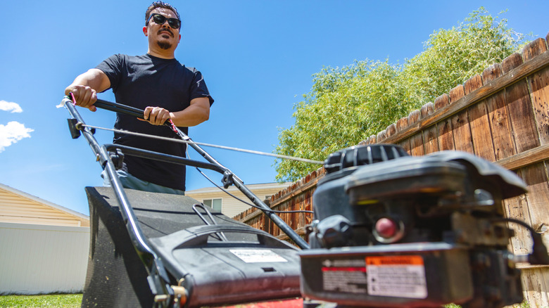 Man pushing a gas-powered mower