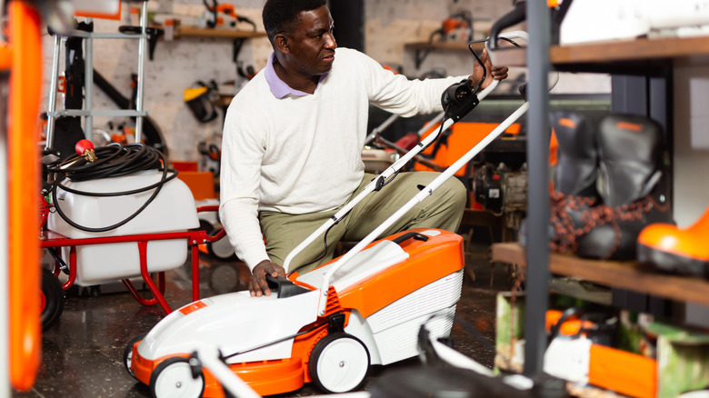 Man looking at a lawn mower in a store