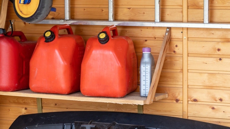 Gas cans neatly stored on a shelf in a garage