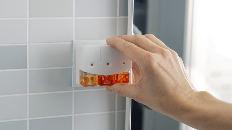 a person plugs in an air freshener