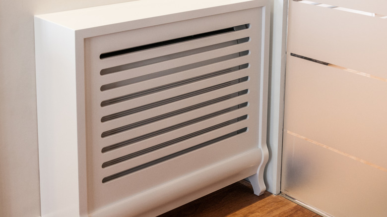 radiator in a stark white cover with horizontal slots