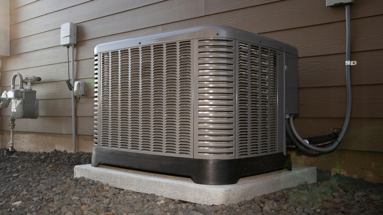 An AC unit on a concrete pad surrounded by gravel