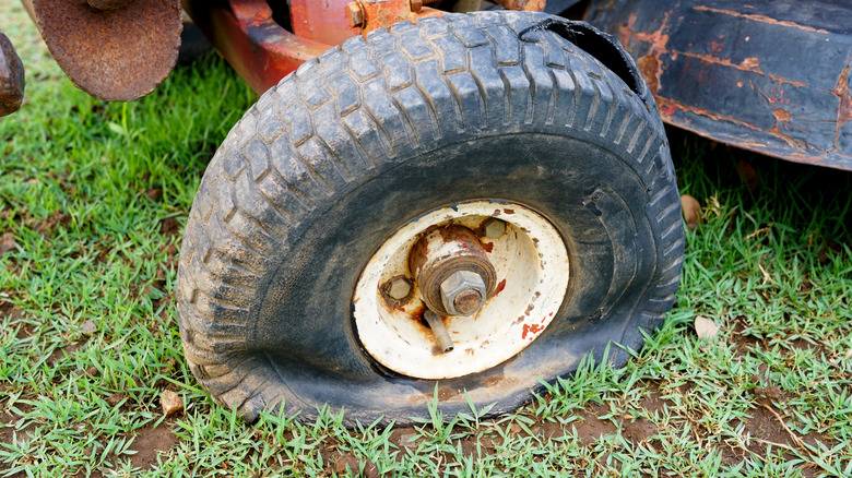 Red lawn mower with a flat tire