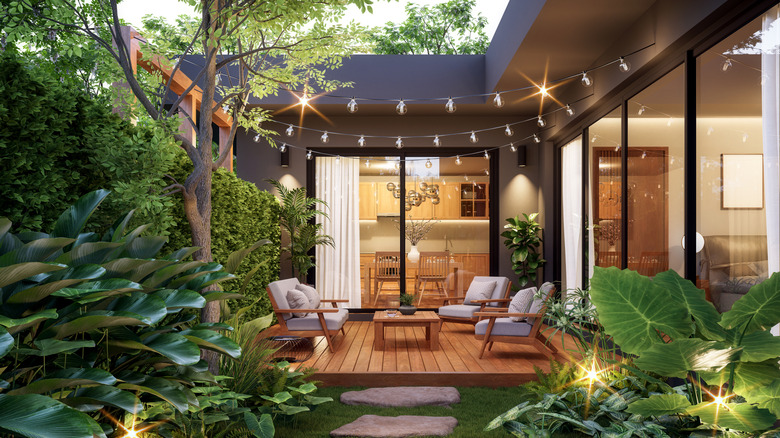 an attractive patio with string lights, chairs, and decking