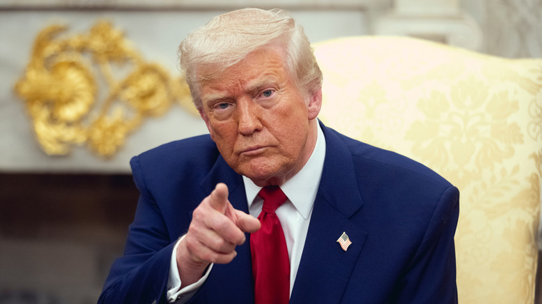 president donald j. trump point right index finger while sitting