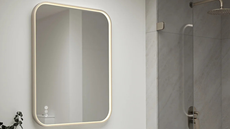A rectangular bathroom mirror with rounded corners and LED lighting