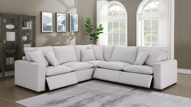 A light gray couch in a living room with reclining footrests slightly elevated