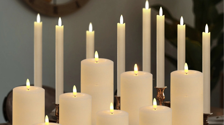 Taper and pillar candles illuminated on a table