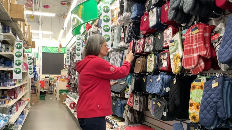 A woman looks at a display of oven mitts at Dollar Tree