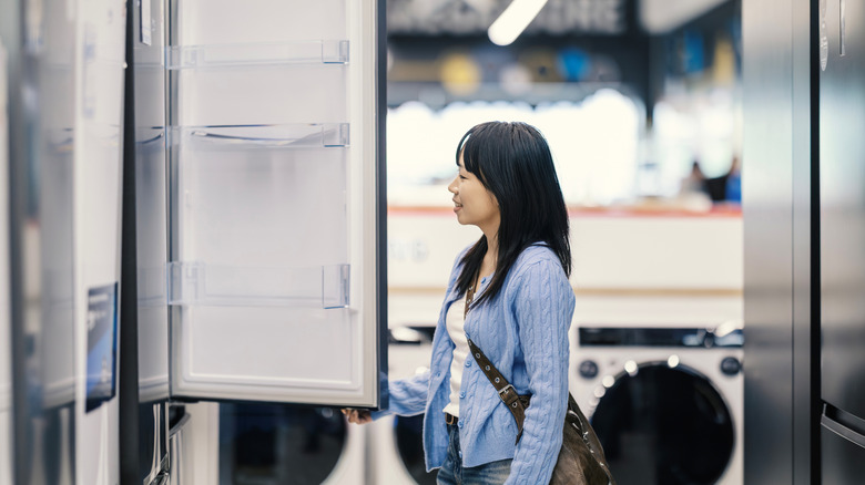 A person looking at a French door fridge in a store