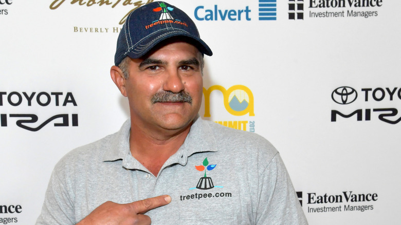 The owner of Tree T-Pee as featured on ABC's Shark Tank pointing to his company's logo on his shirt.