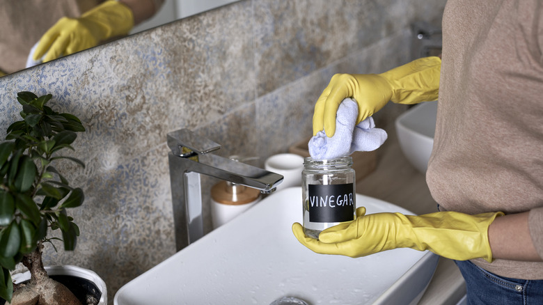 Woman dipping a cloth into vinegar to clean