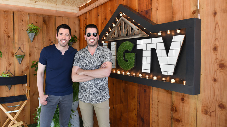 Drew and Jonathan Scott stand next to each other at an HGTV event