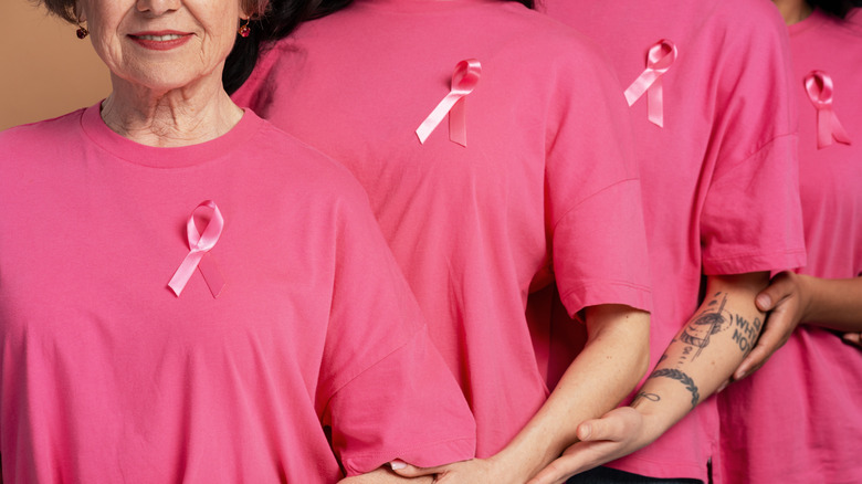 group of women wearing pink shirts and pink breast cancer awareness ribbons