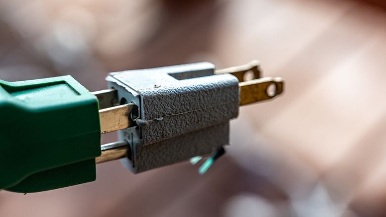 Adapting a three-prong plug for a two-prong receptacle