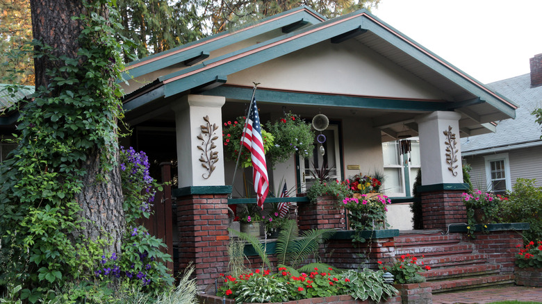 An American flag hangs in front of a historic Craftsman-style home