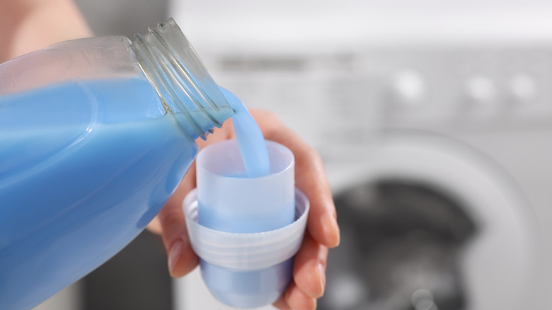 pouring fabric softener into a cap